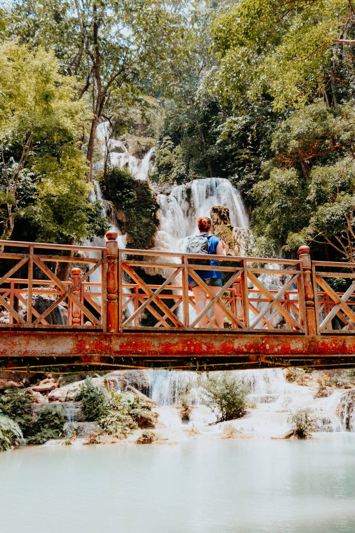 Person auf Brücke vor Wasserfall