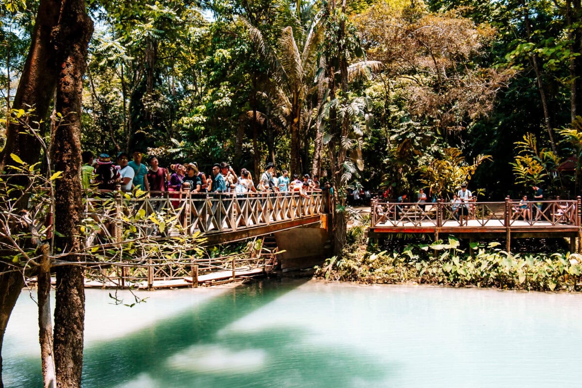 Menschen auf Holzbrücke im tropischen Wald