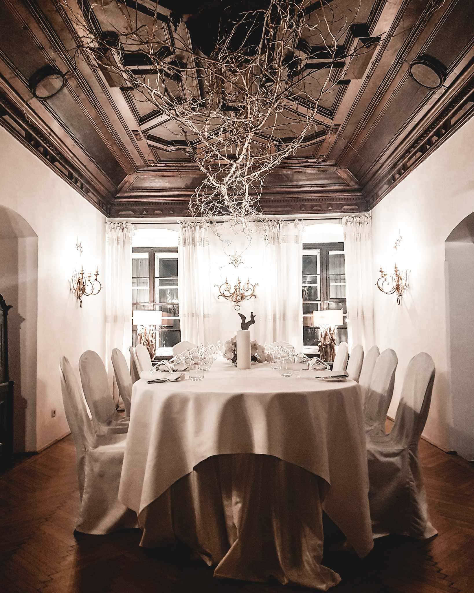 Tafel und Esstisch unter Holzgewölbe im Stiftskulinarium zum Mozart Dinner in Salzburg