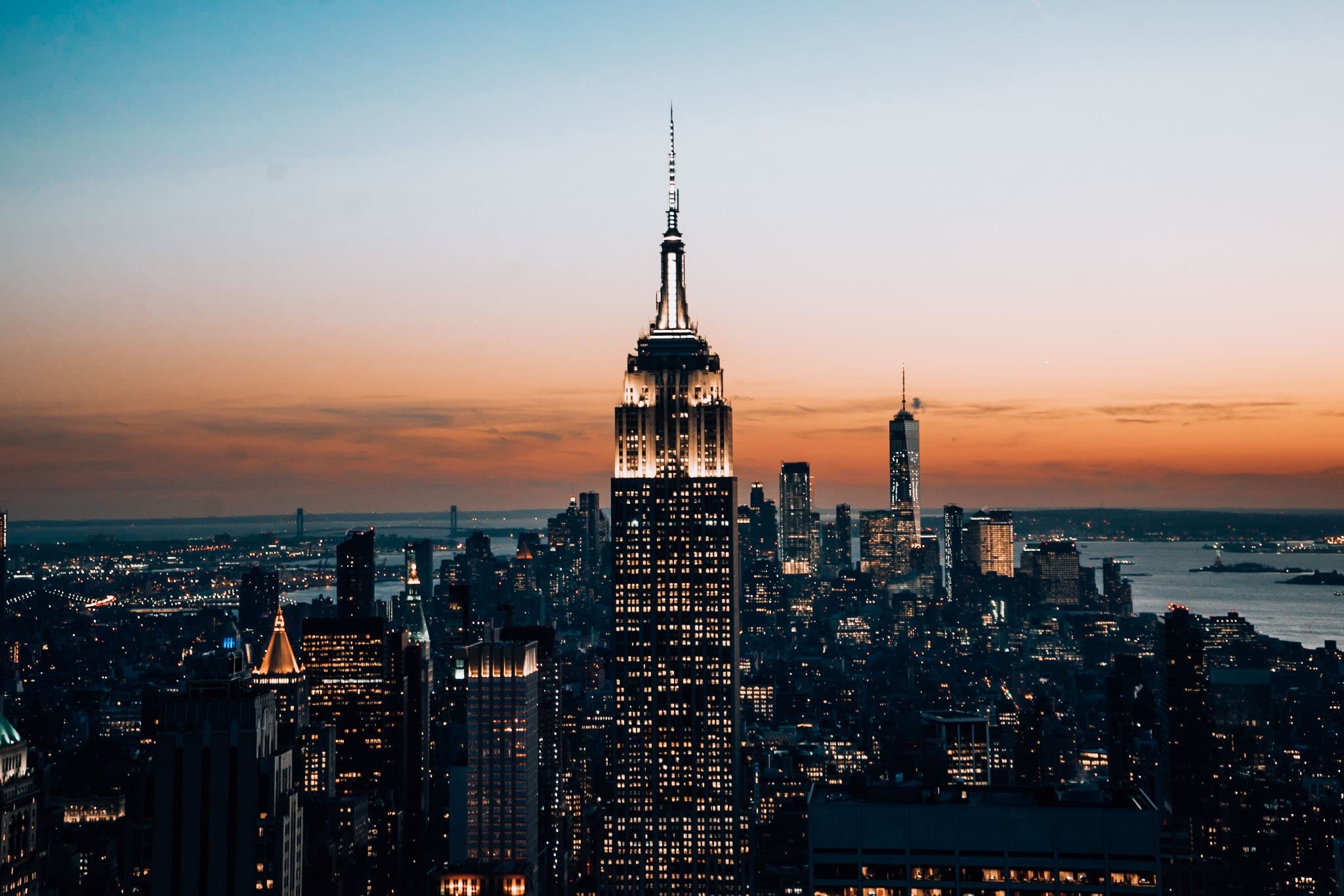 Empire State Building bei Nacht vor orangenem Sonnenuntergang