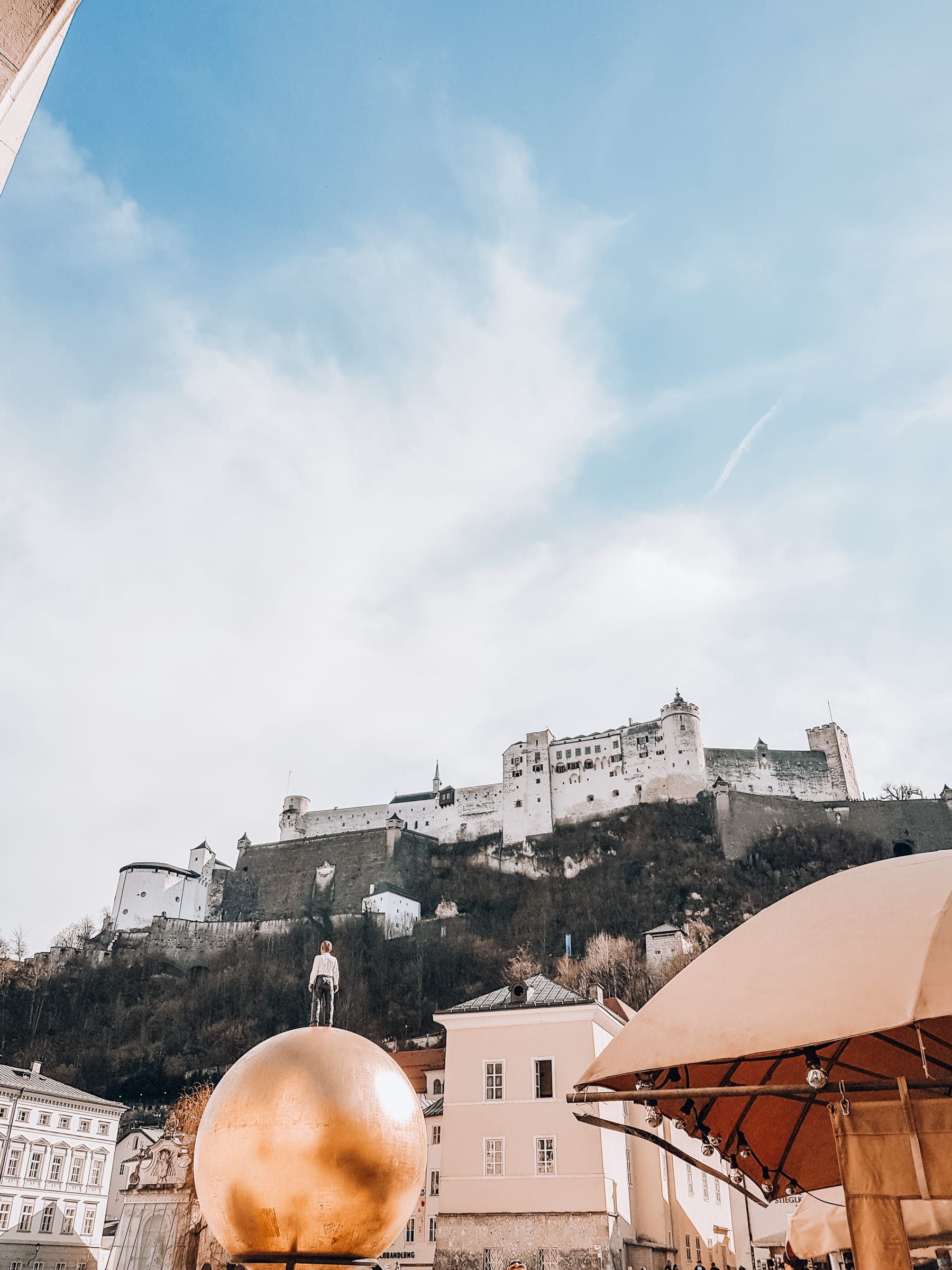 Skulptur Mann auf goldener Kugel in Salzburg vor Festung Hohensalzburg