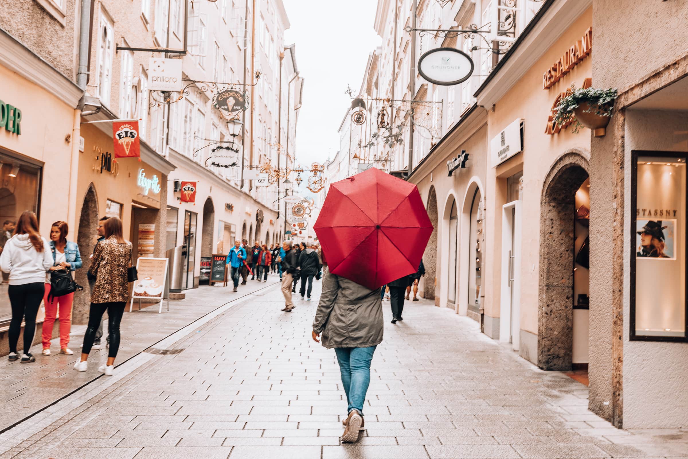 Frau mit Schirm in Salzburger Altstadt bei Schnürlregen, Regen in Salzburg
