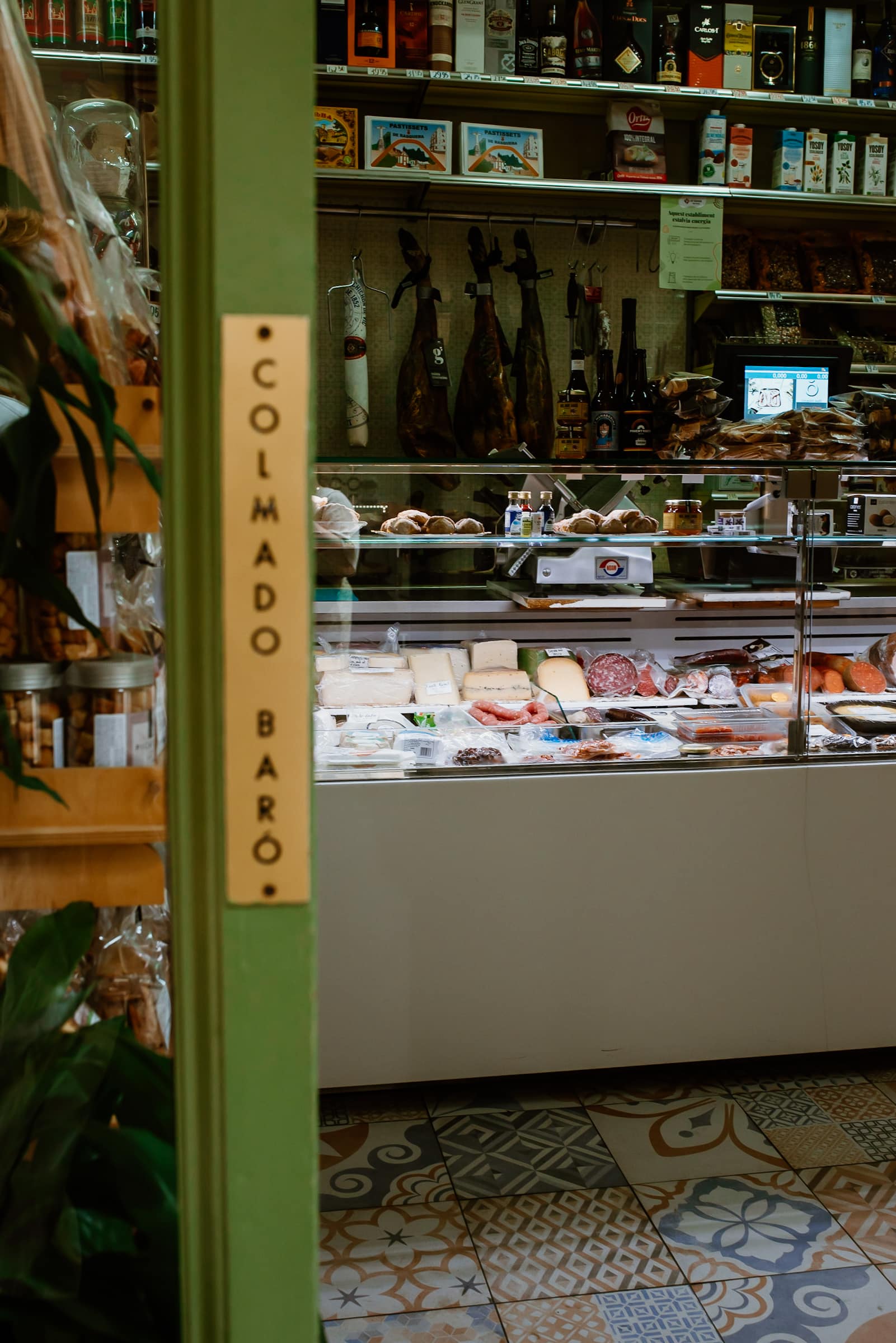Käsetheke mit Schinken bei Colmado Baro in Reus, Spanien