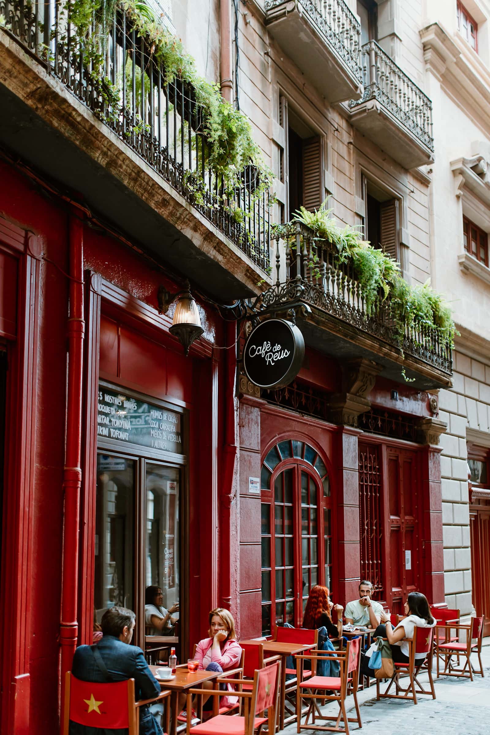 Terrasse vom Café de Reus mit roter Fassade