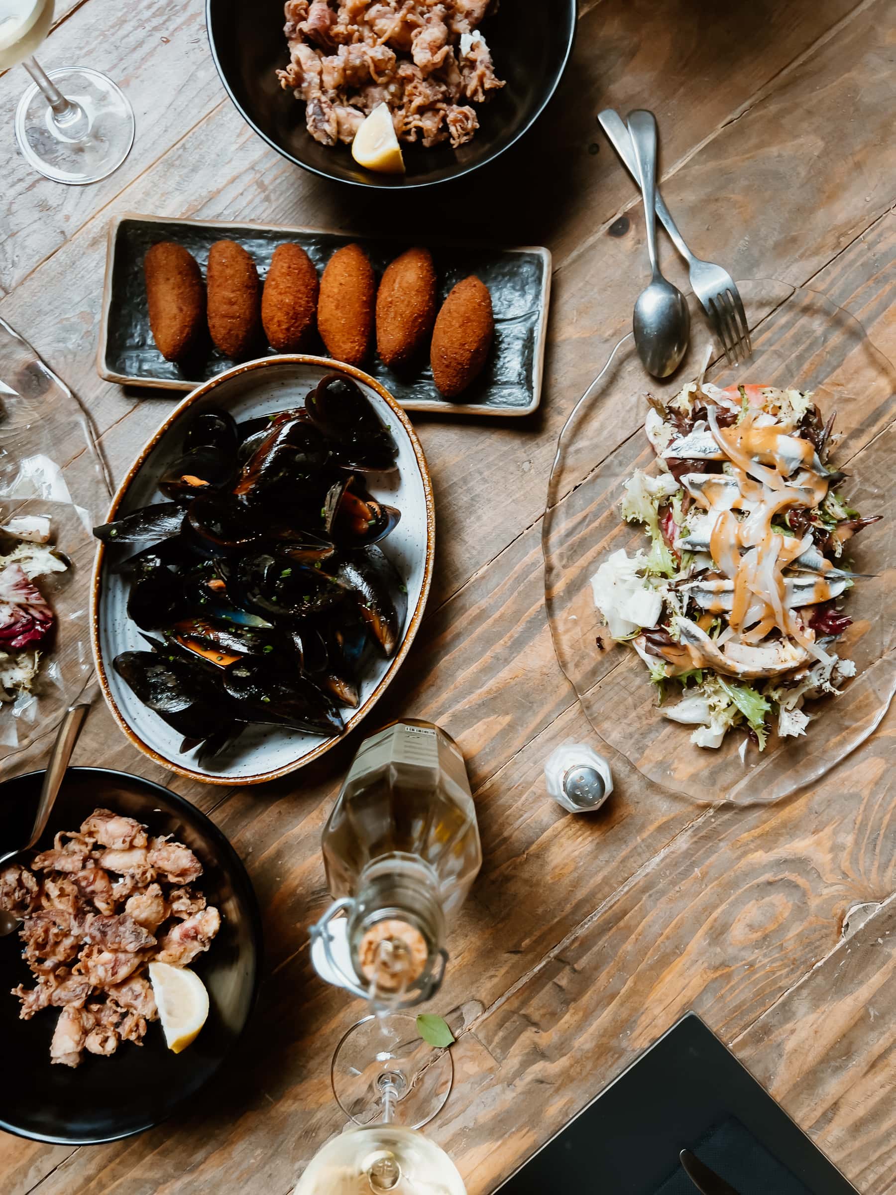 Gedeckter Tisch im Vermuts Rofes in Reus mit Muscheln, Salat und frittierten Kroketten