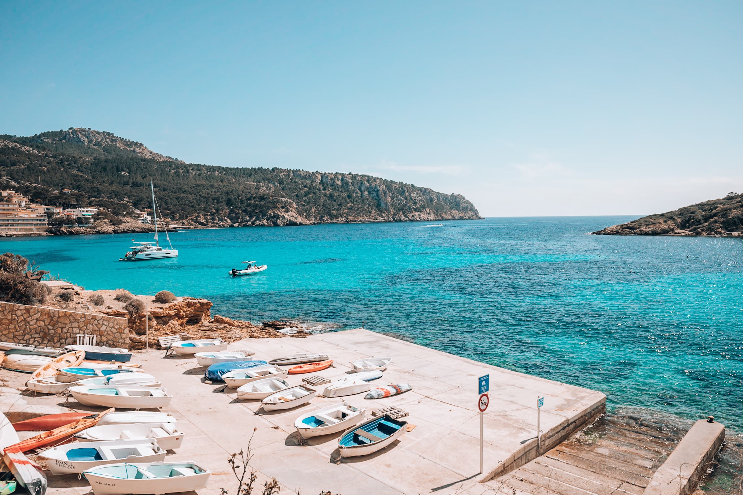 Idyllischer Küstenabschnitt mit Booten und blauem Wasser, perfekter Ort für Urlaub und Entspannung.