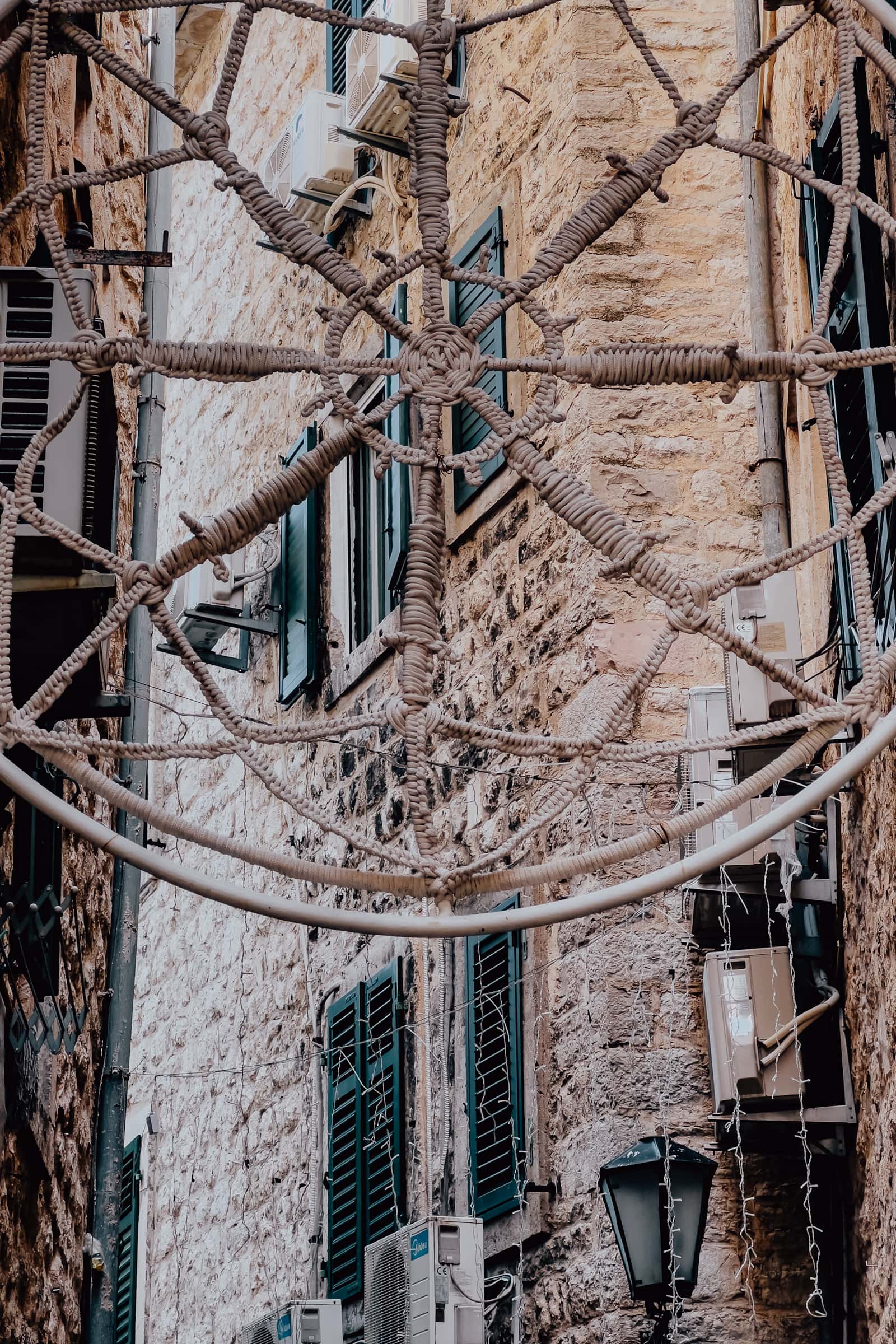 Seilnetz an historischer Steinfassade mit Fensterläden.