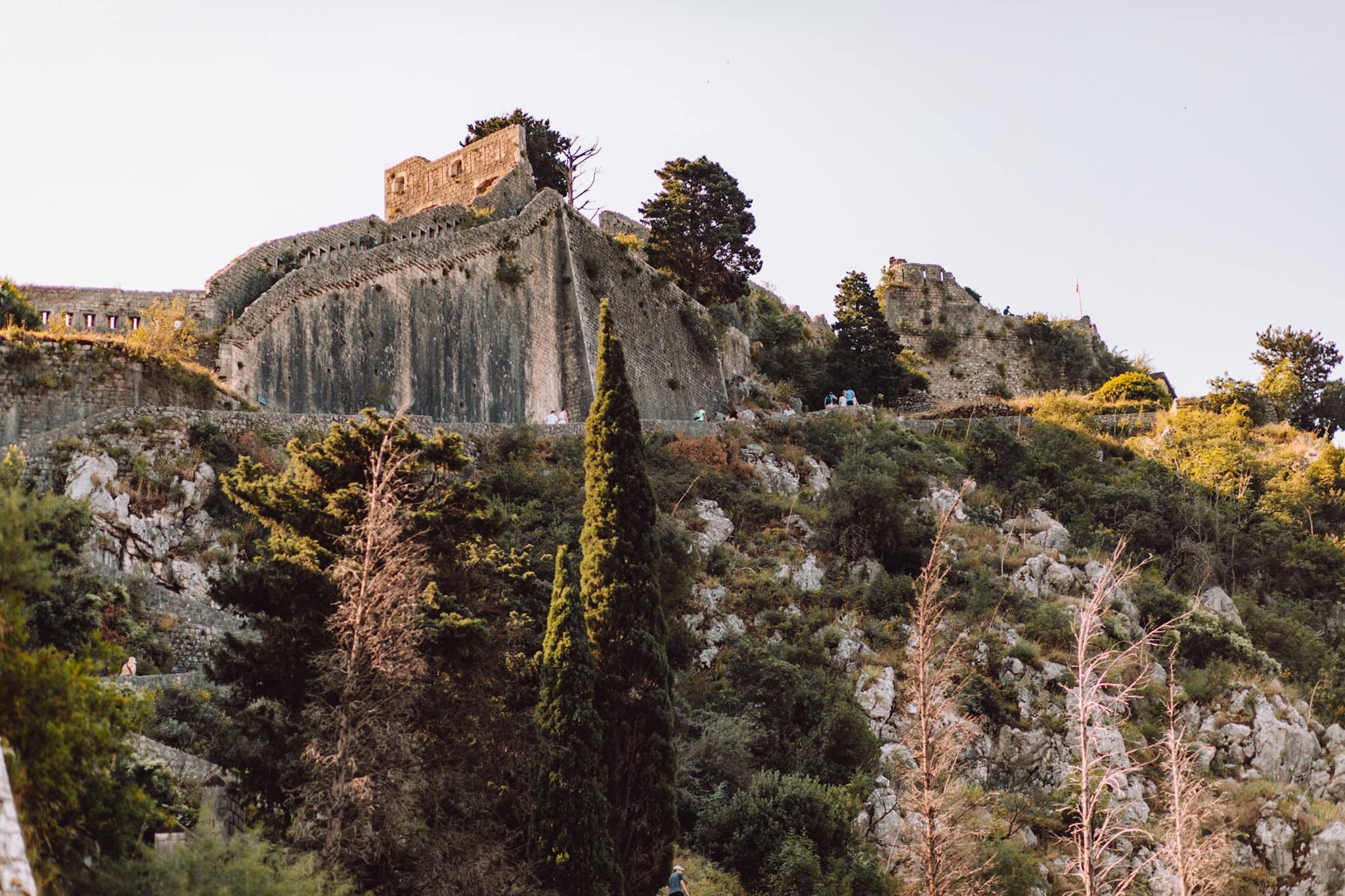 Burg auf Hügel mit Bäumen beim Sonnenuntergang.