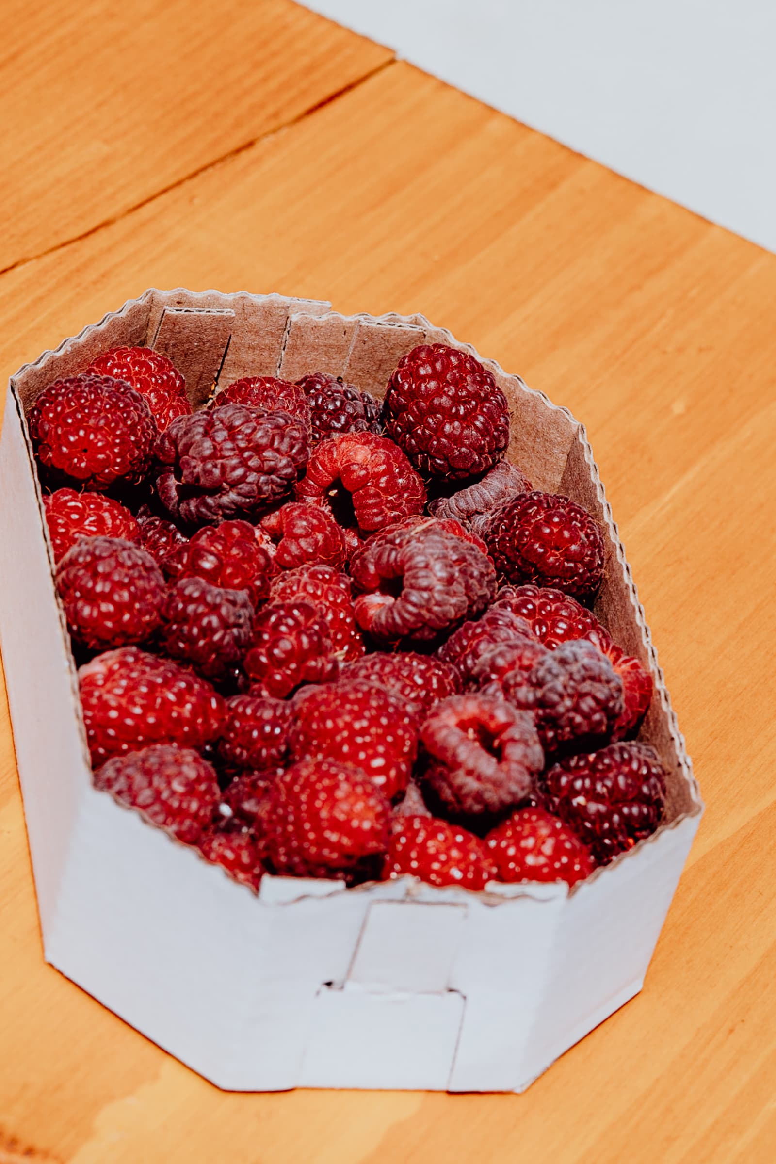 Frische Himbeeren in einer Pappschachtel.