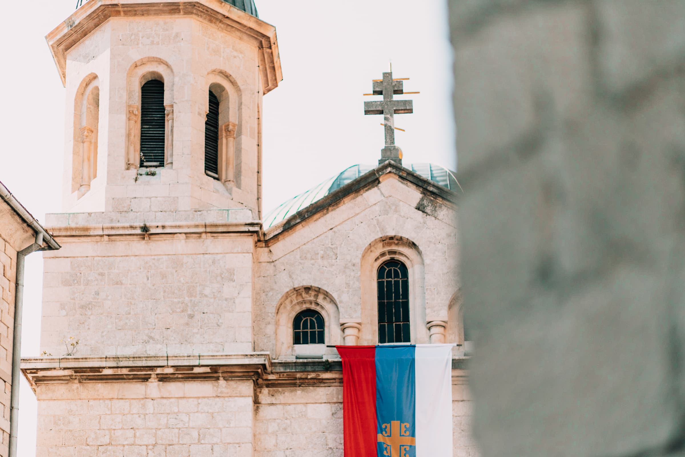 Kirche mit Kreuz und bunten Fahnen in der Altstadt von Kotor.