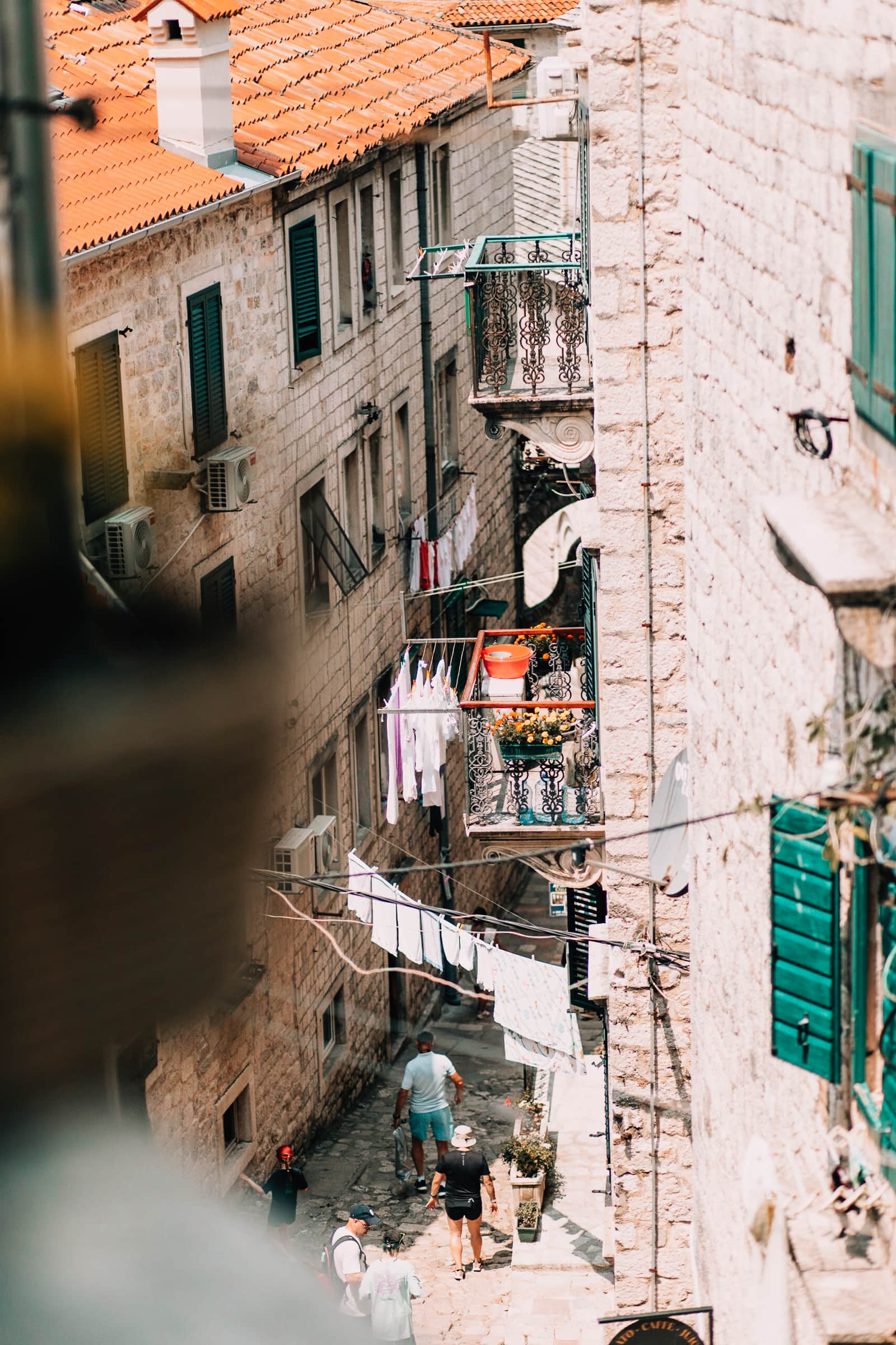 Gasse mit Wäscheleinen zwischen alten Steinhäusern.