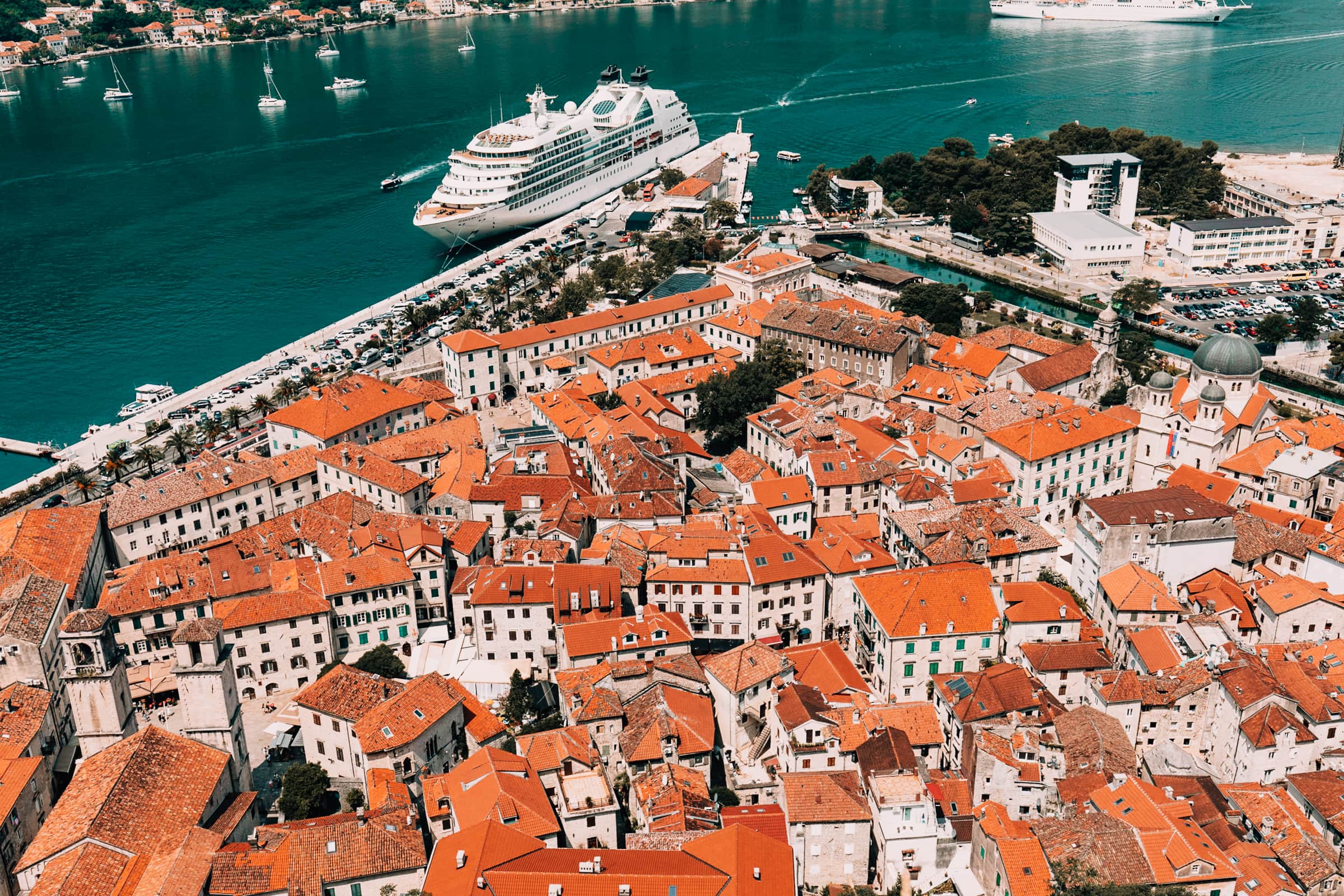 Kreuzfahrtschiff neben historischer Altstadt am Meer.