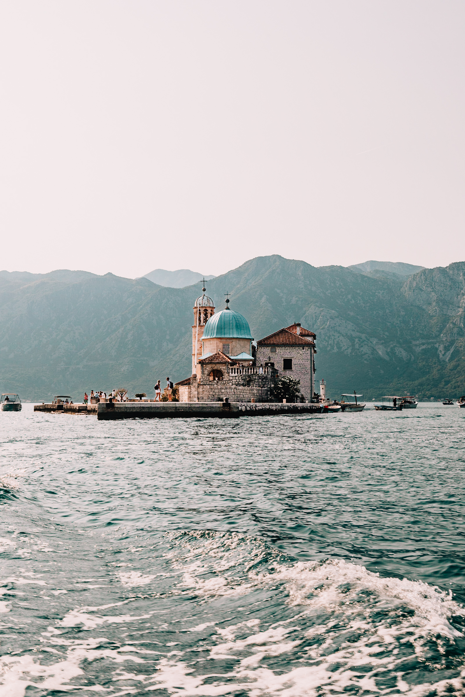 Kirche auf Insel mit Bergen im Hintergrund