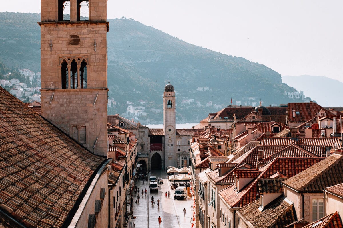 Historische Altstadtgasse mit Ziegeldächern und Turm.