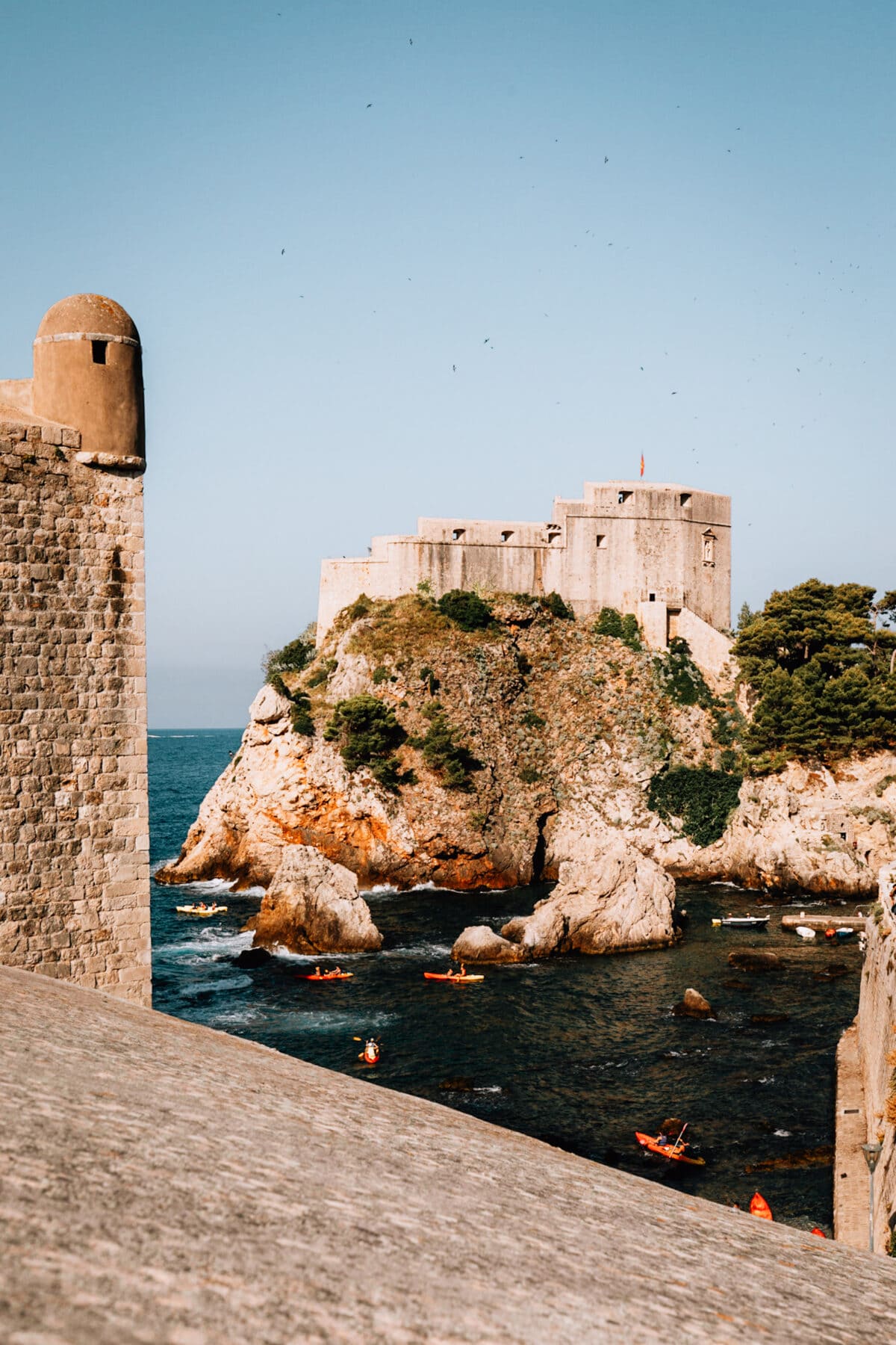 Festung an felsiger Küste mit Kajakfahrern