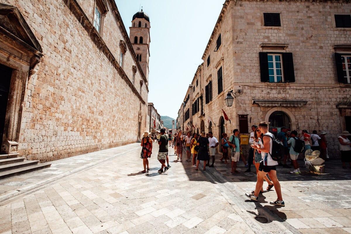 Touristen in historischer Altstadt bei Sonnenschein.
