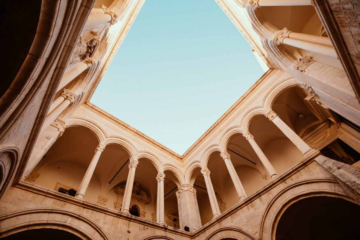 Historisches Gebäude mit Bögen und klarem Himmel.