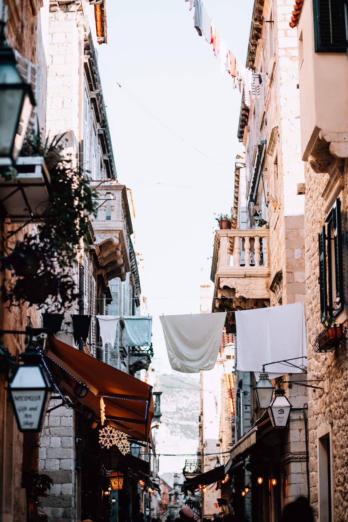 Enge Gasse mit Wäscheleine und Geschäften.