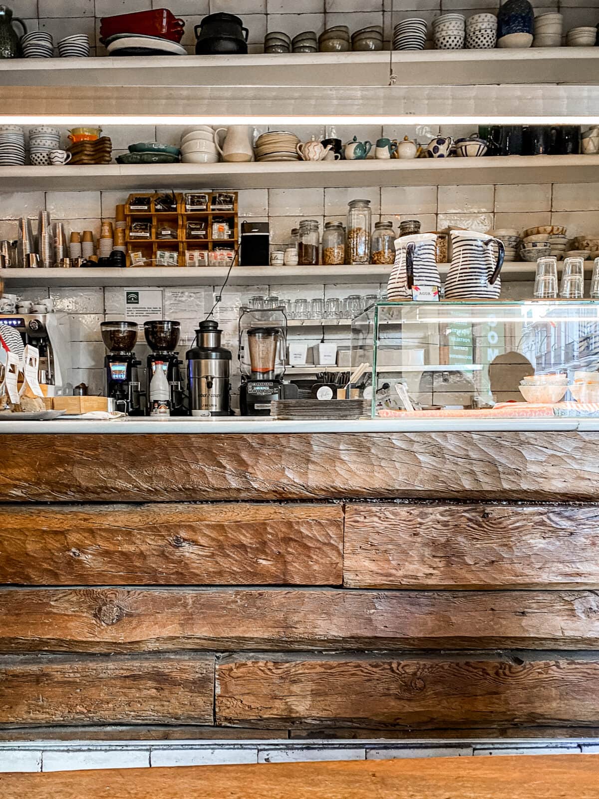 Gemütliches Café-Innere mit Kaffeeausrüstung und Regalen.