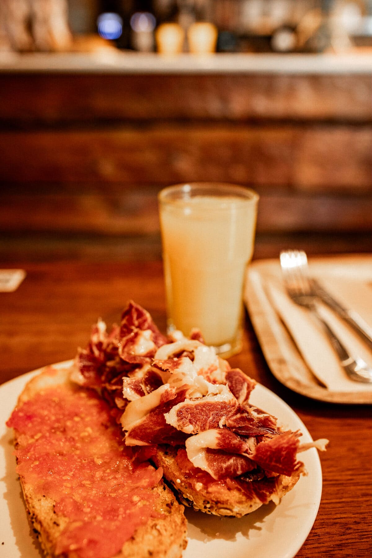 Belegtes Brot mit Schinken und Tomate, Orangensaft.