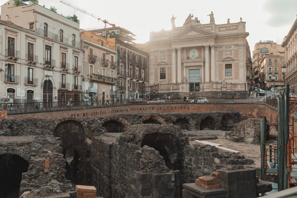 Antike Ruinen vor historischem Gebäude in Stadt.