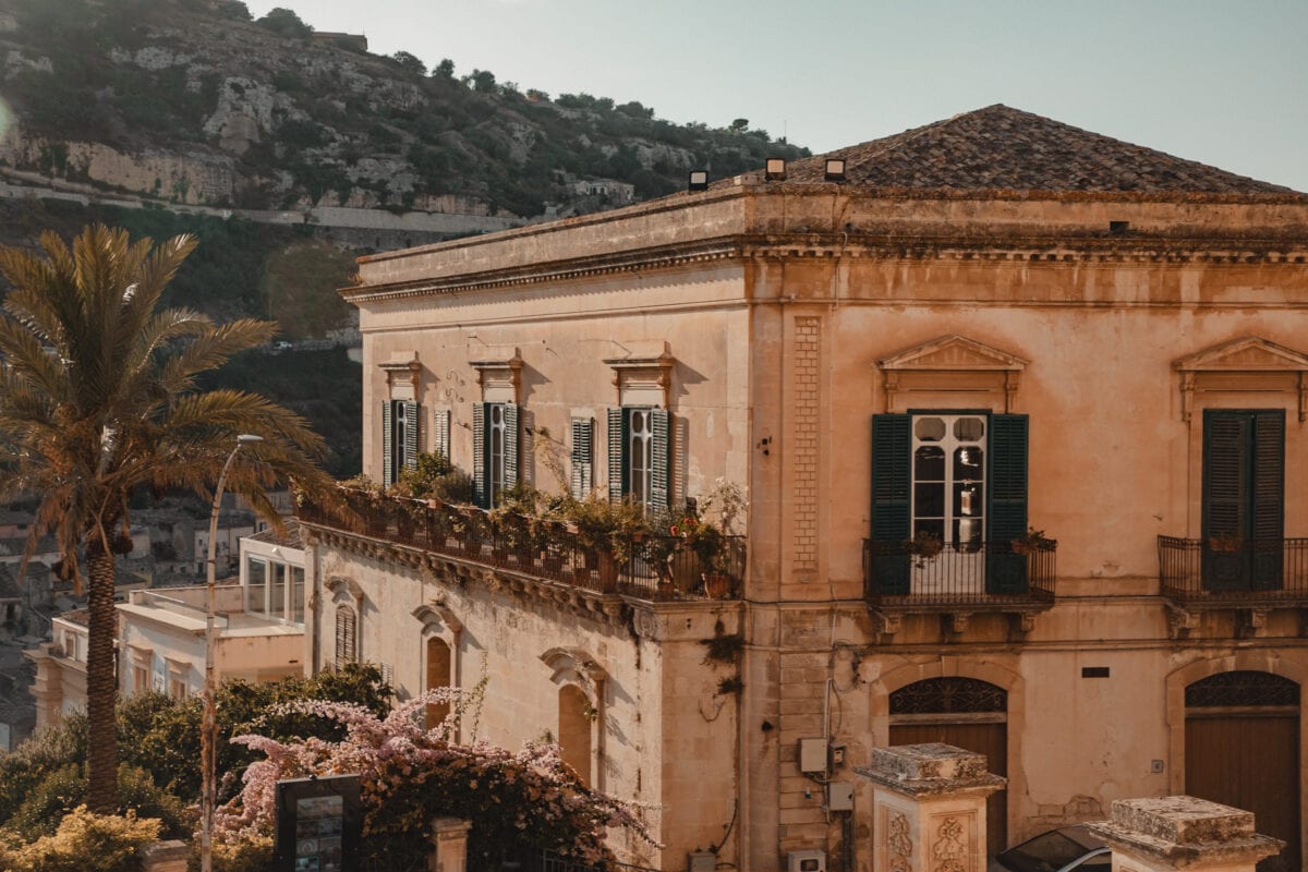 Historisches Gebäude mit Balkonen und Palmen