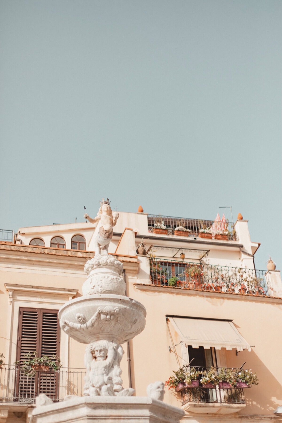 Historische Brunnenstatue vor Gebäuden