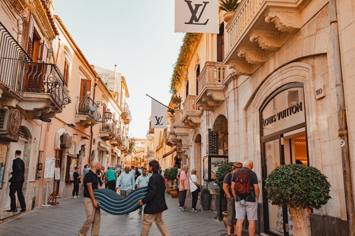 Lebhafte Straße mit Louis Vuitton Geschäft.