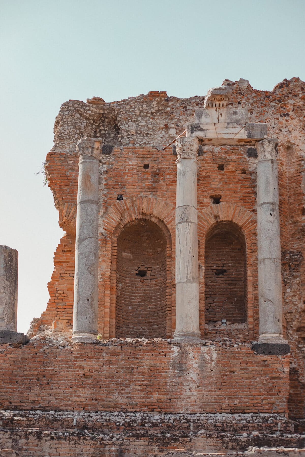 Alte Ruine mit Säulen und Ziegelmauer.