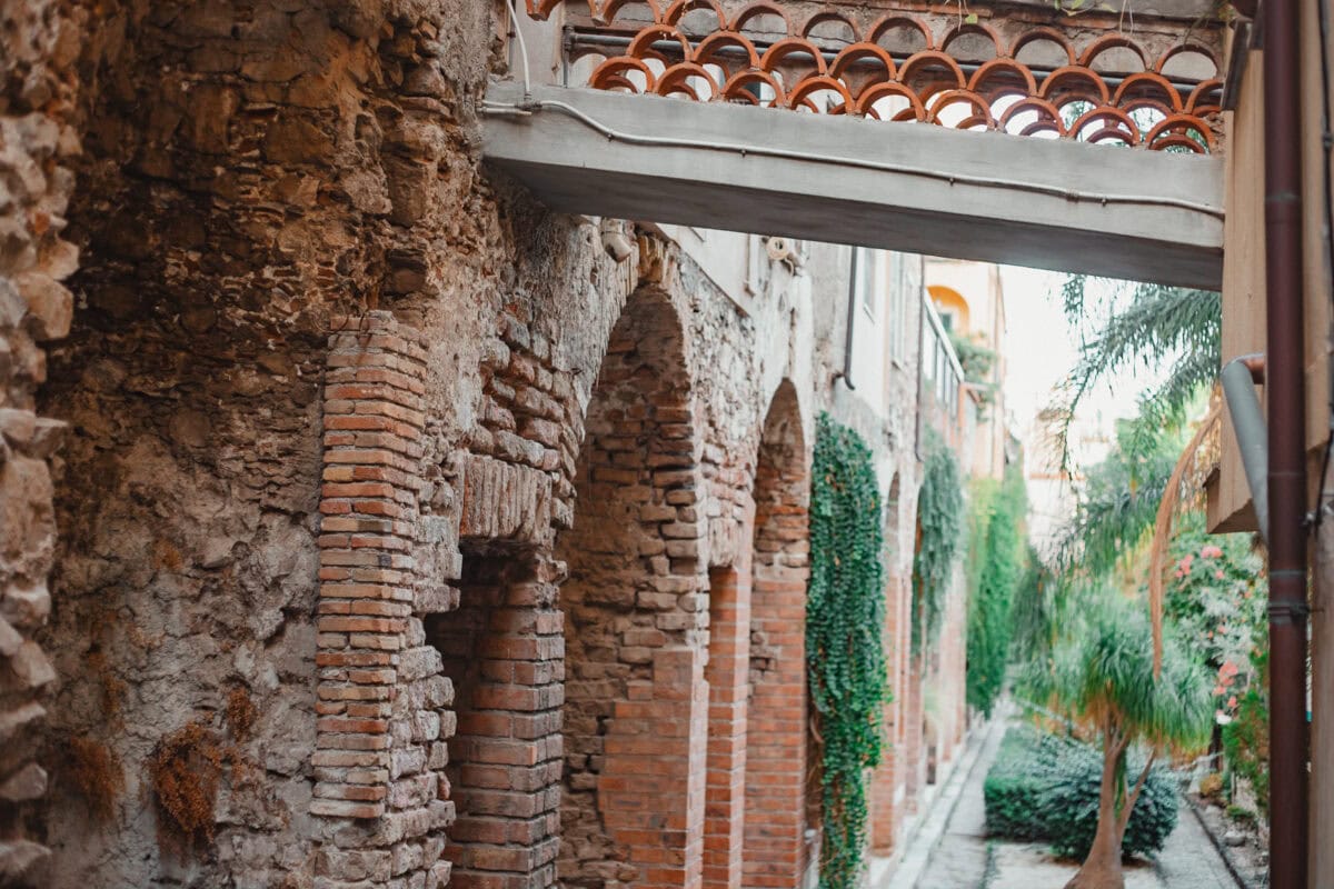 Historischer Bogengang mit Pflanzenbewuchs