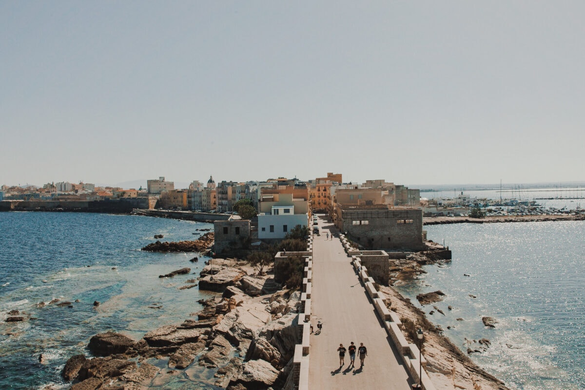Küstenstadt-Panorama mit Promenade und Spaziergängern.