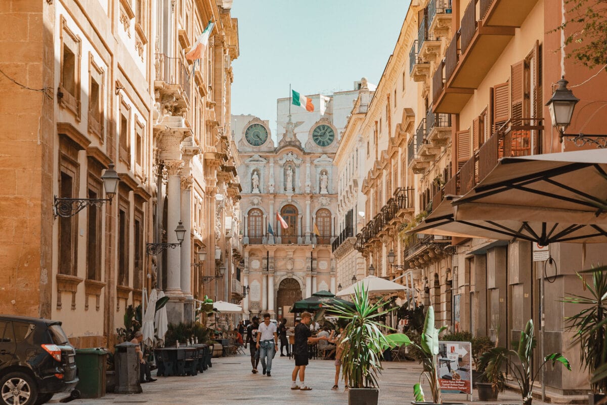 Belebte Straße mit historischen Gebäuden in Italien.