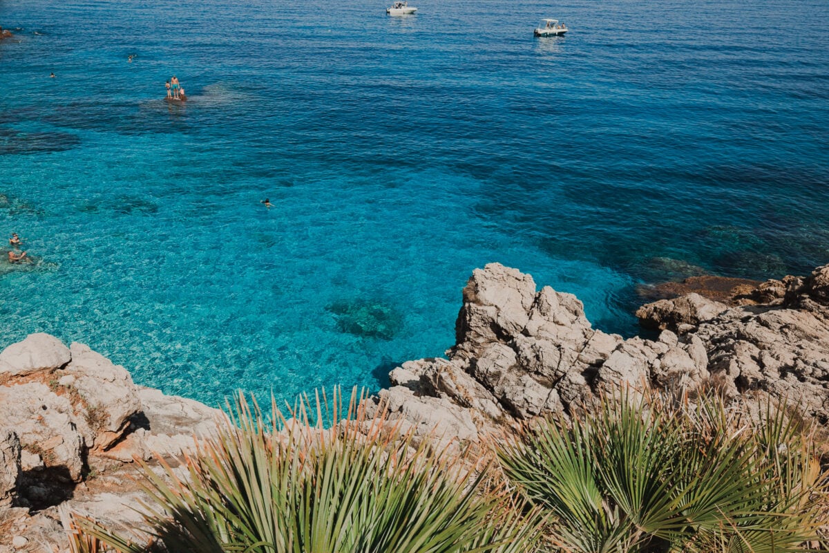 Klares Wasser, Felsen und Pflanzen am Mittelmeer.