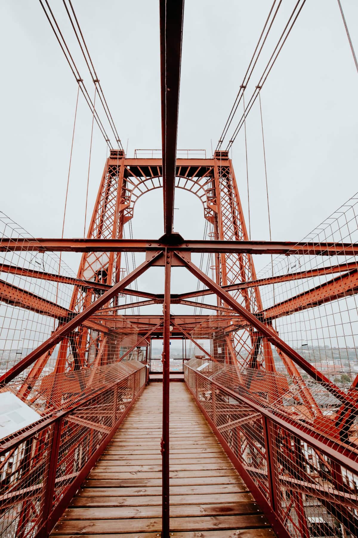 Roter Brückenturm mit hölzernem Gehweg.