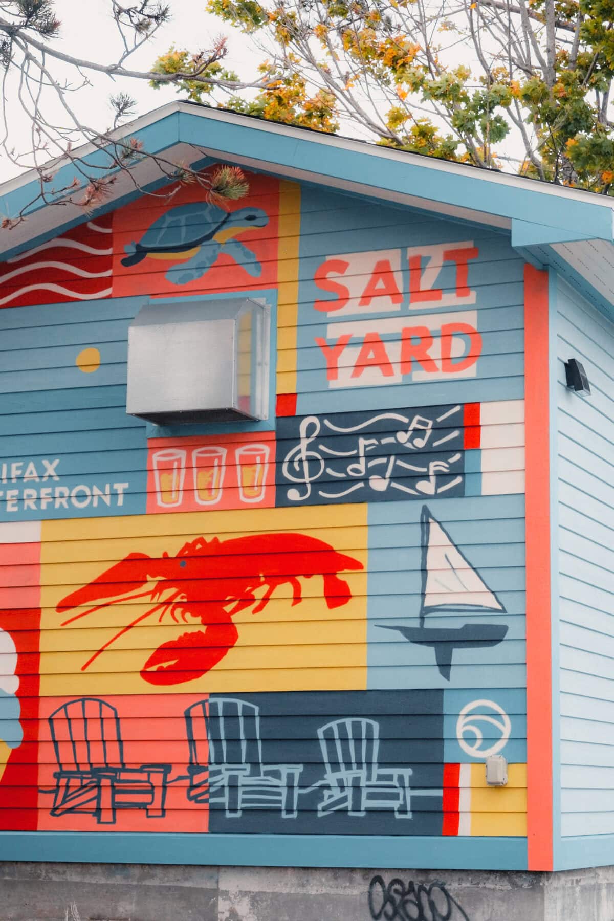 Buntes Wandbild mit Meereselementen auf Hauswand.