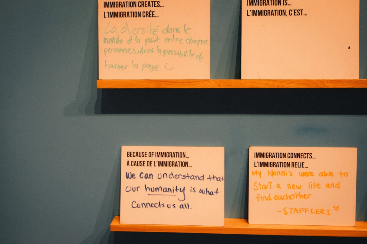 Handgeschriebene Zitate über Einwanderung auf Schildern.