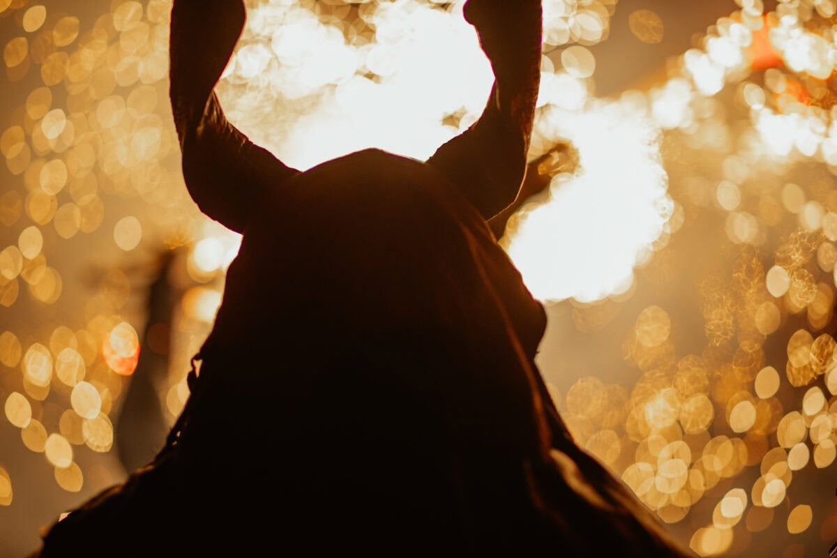 Schattenriss mit Hörnern vor Funken und Licht.