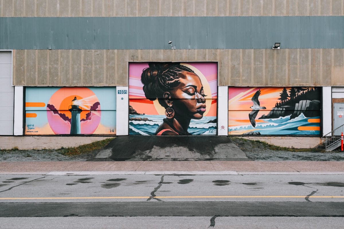 Bunte Wandmalereien mit Leuchtturm und Frau