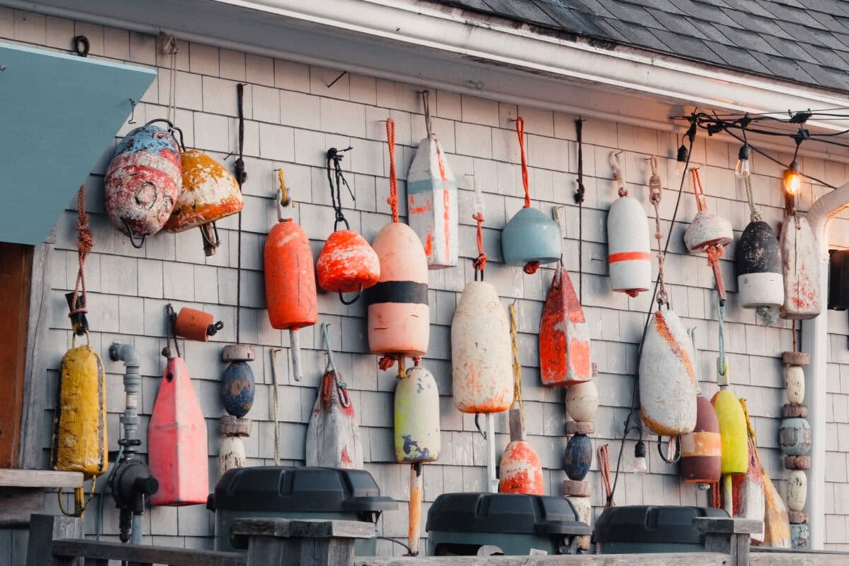 Bunte Bojen hängen an einer Holzwand.