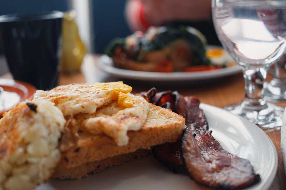 Frühstücksteller mit Rührei und Speck.