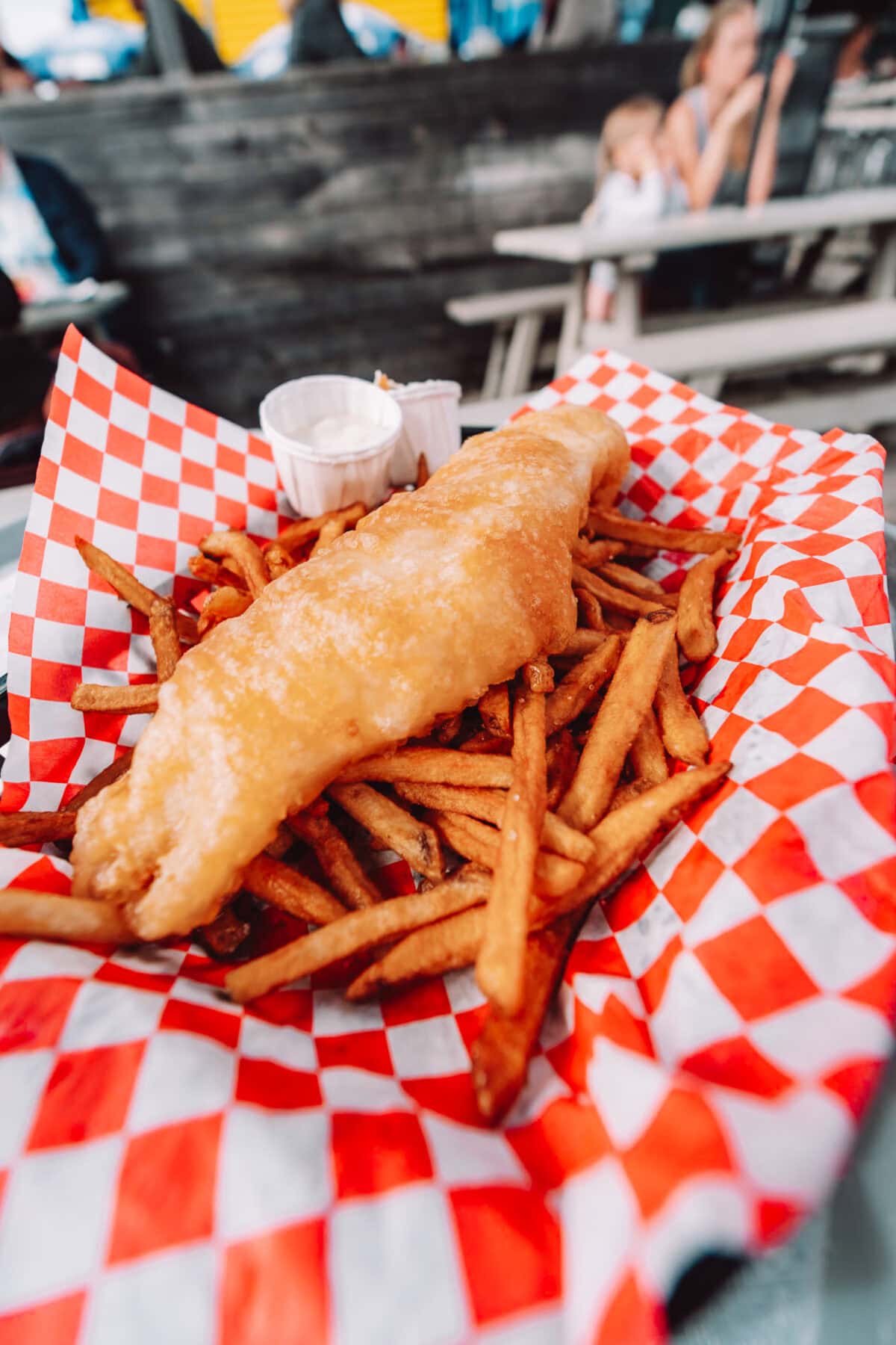 Fisch und Pommes auf kariertem Tablett
