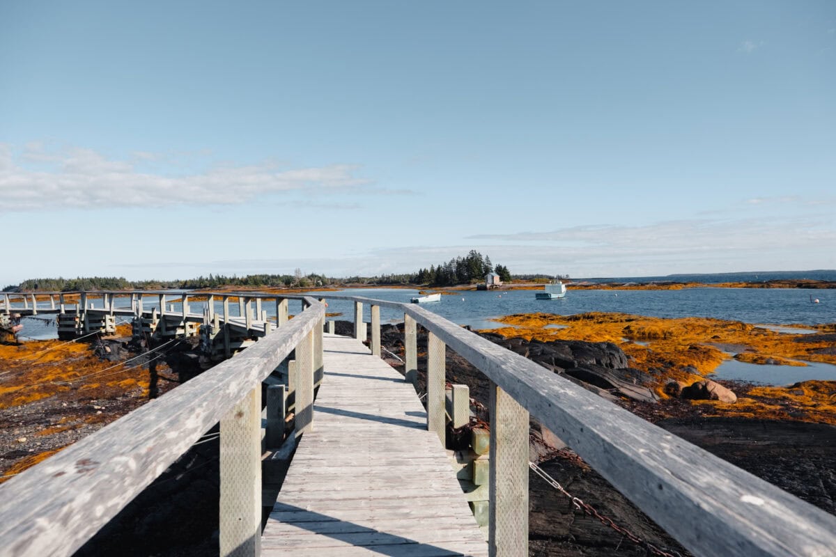 Holzsteg am Wasser mit Booten und Insel