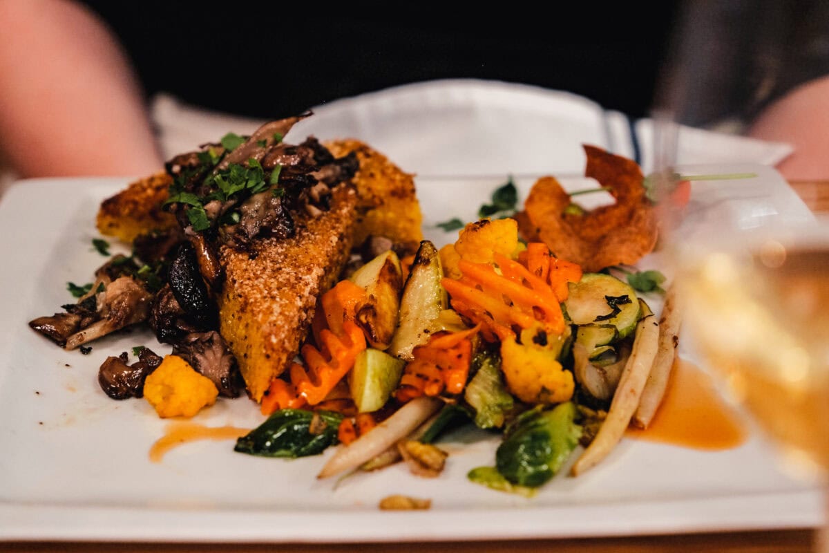 Gericht mit Gemüse und gegrilltem Brot auf Teller