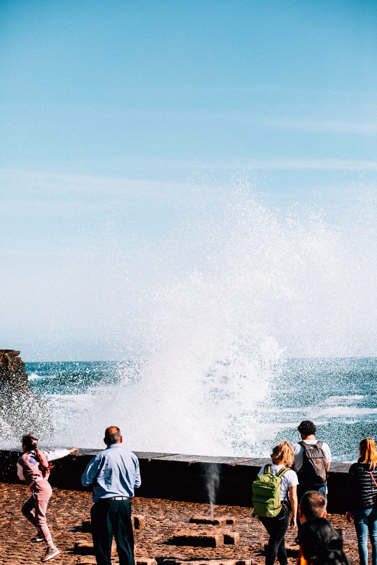 Menschen beobachten Wellen am Ufer