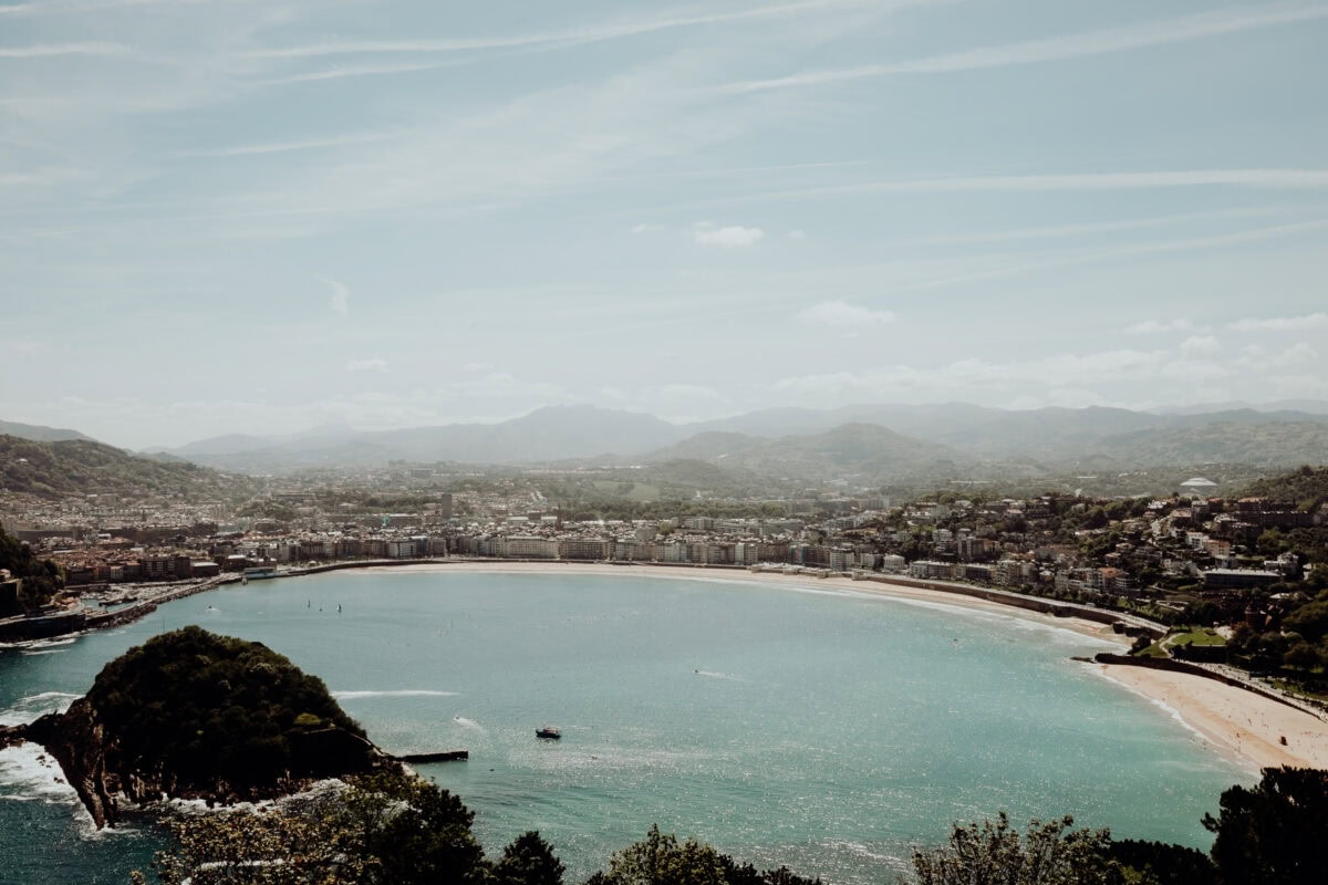 Panoramablick auf Küstenstadt und Berge im Hintergrund.