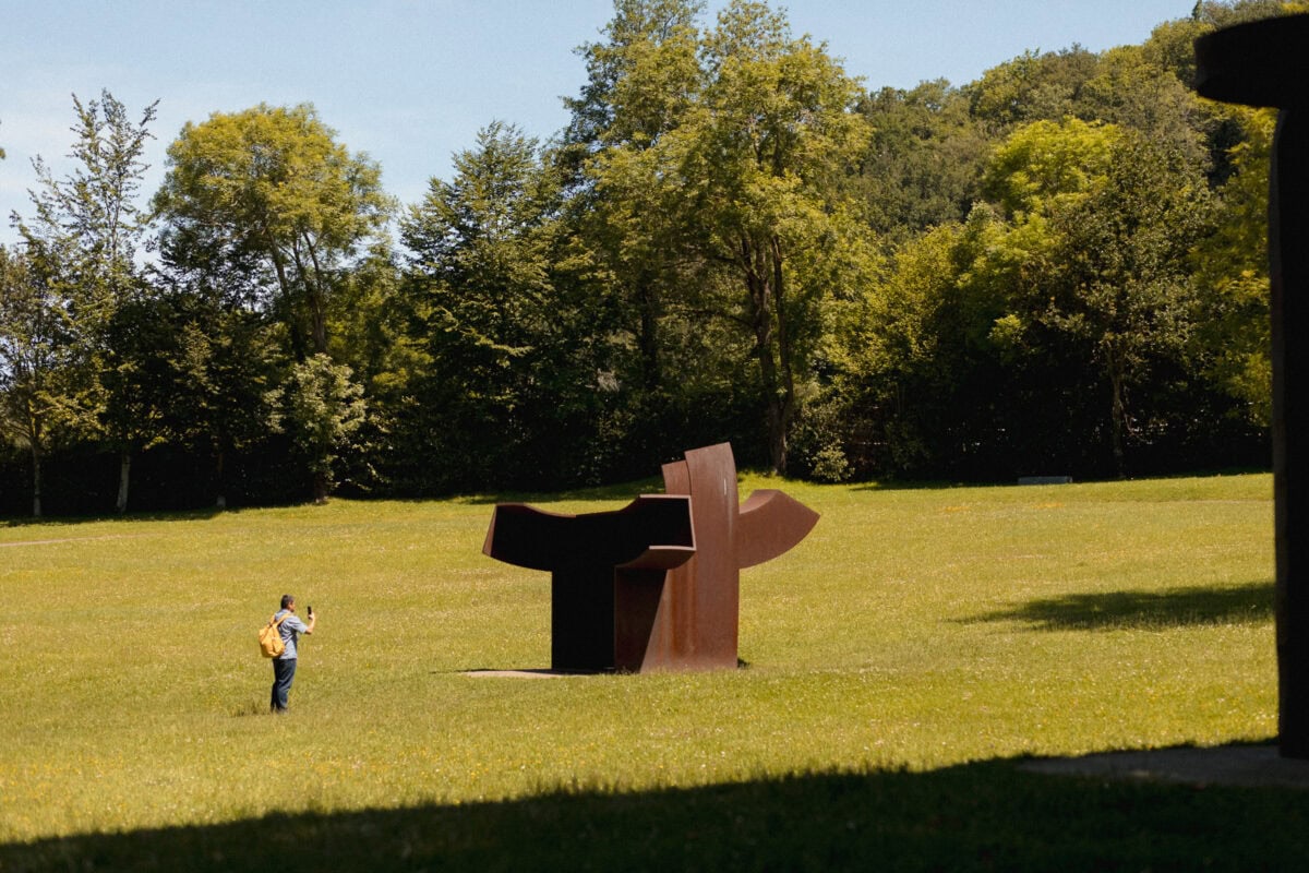 Person fotografiert Statue im Park