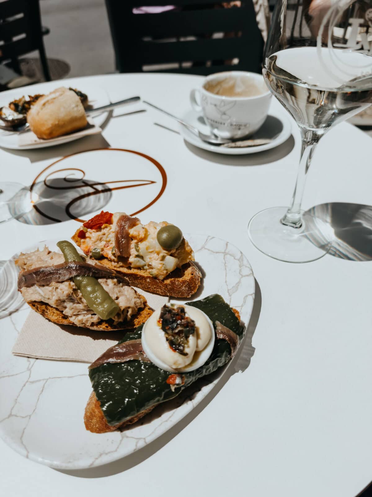 Tapas und Wein auf einem Café-Tisch.
