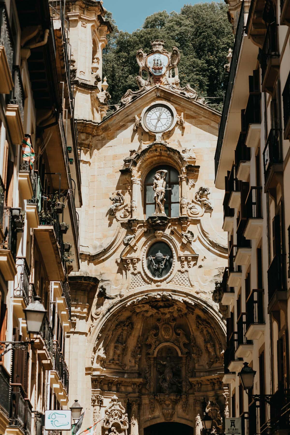 Historische Kirche zwischen Häusern in sonniger Gasse.