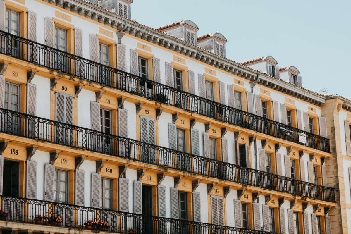 Gelbes Gebäude mit vielen Balkonen und Fenstern.