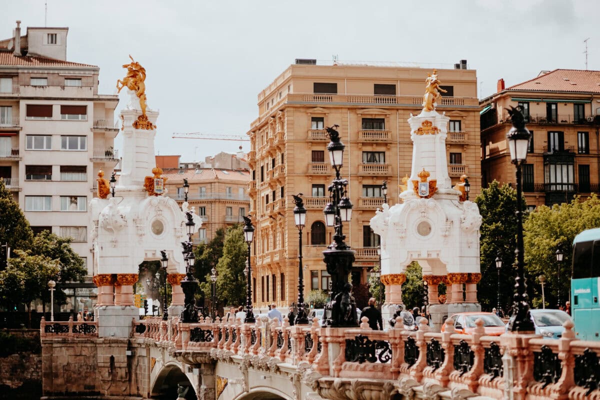 Historische Brücke vor Stadthäusern mit Statuen.